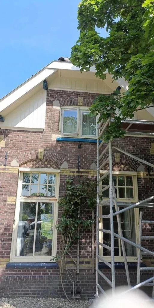 Bakstenen woning met erker en steiger bij het bovenste raam